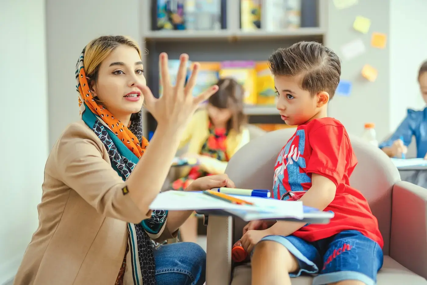 O'qituvchi bolaga barmoqlari bilan sanashni o'rgatmoqda
